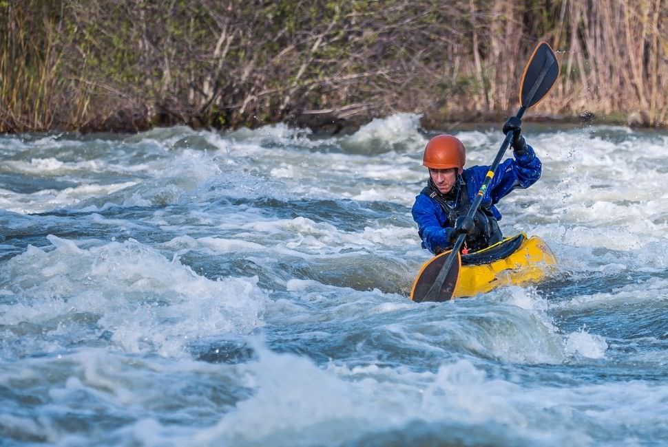 a man whitewater kayaking